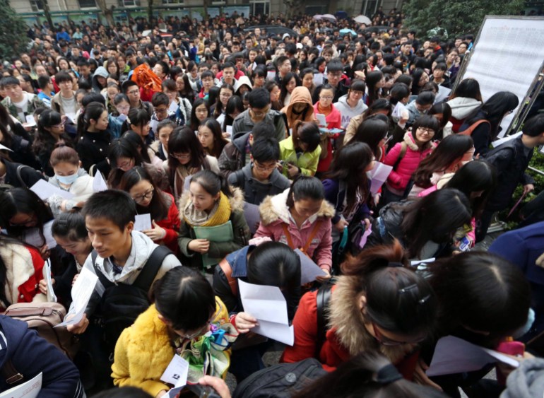 This picture taken on November 24, 2013 shows a group of candidates arriving for China's national civil service exam in a university in Nanjing, east China's Jiangsu province. More than one million people took China's national civil service exam on November 24, officials said, but faced huge odds against clinching one of the few government jobs available. CHINA OUT AFP PHOTO (Photo by AFP)
