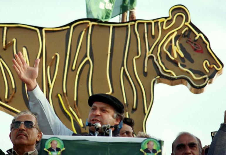 Nawaz Sharif, leader of the Pakistan Moslem League (PML) party, addresses a election rally in Islamabad January 22. Behind him is a metal cut-out of a tiger, illuminated with neon strips.