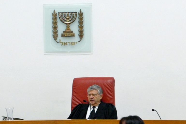 Aharon Barak (C), Israel's Supreme Court Chief Justice, opens hearings in Jerusalem February 9, 2004. Israel's Supreme Court opened hearings on Monday into the legality of a West Bank barrier the government says stops suicide bombers but which civil liberties groups say causes Palestinian hardship. REUTERS/Gil Cohen Magen GCM/GM/JV/AA