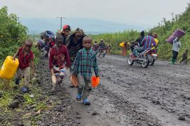 Civilians carry their belongings as they flee after heavy gunfire that raised fears of M23 rebels advancing along a road from Sake near Goma in the North Kivu province of the Democratic Republic of Congo on February 9, 2023 [File: Reuters/Djaffar Sabiti]
