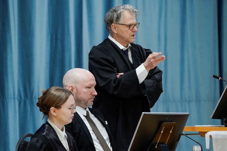 Anders Behring Breivik sits between his representatives at court