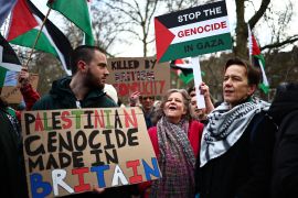 Pro-Palestinian activists and supporters wave Palestinian flags and hold placards during a demonstration in central London on January 6, 2024, calling for a ceasefire in Israel&#039;s war on Gaza [Henry Nocholls/AFP]