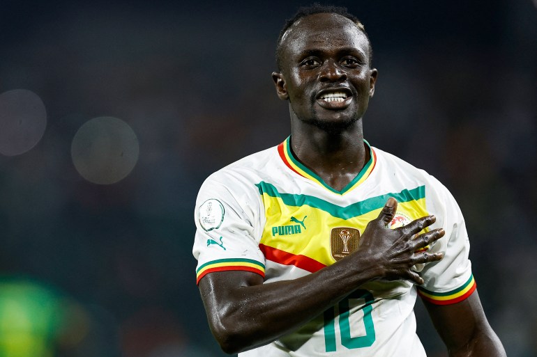 Sadio Mane smiles and puts his right hand to his heart