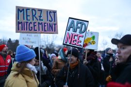 Participants hold up placards reading &#039;No to AfD&#039;, right, during a demonstration against racism and far-right politics in front of the Reichstag building in Berlin, Germany on January 21, 2024 [Christian Mang/AFP]