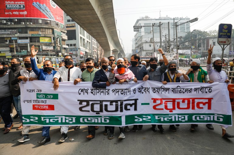 Activists of Bangladesh's opposition alliance march holding a banner with the words "Hartal" meaning strike 
