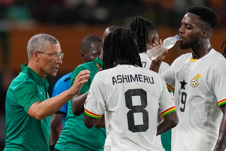 Ghana's head coach Chris Hughton, left, gives directions to his players