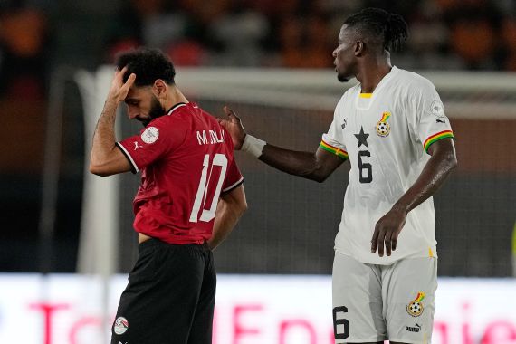Egypt's Mohamed Salah, left, leaves the field after sustaining an injury