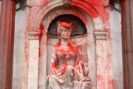 A close up of the monument to Queen Victoria splashed with red paint