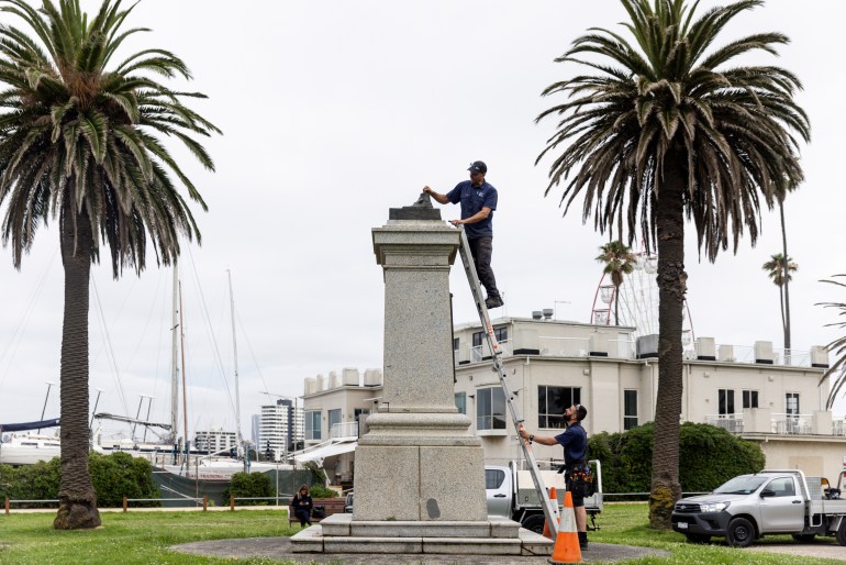 The plinth where the James Cook statue stood before it was cut down on Thursday. Workers are removing what's left of the statue.
