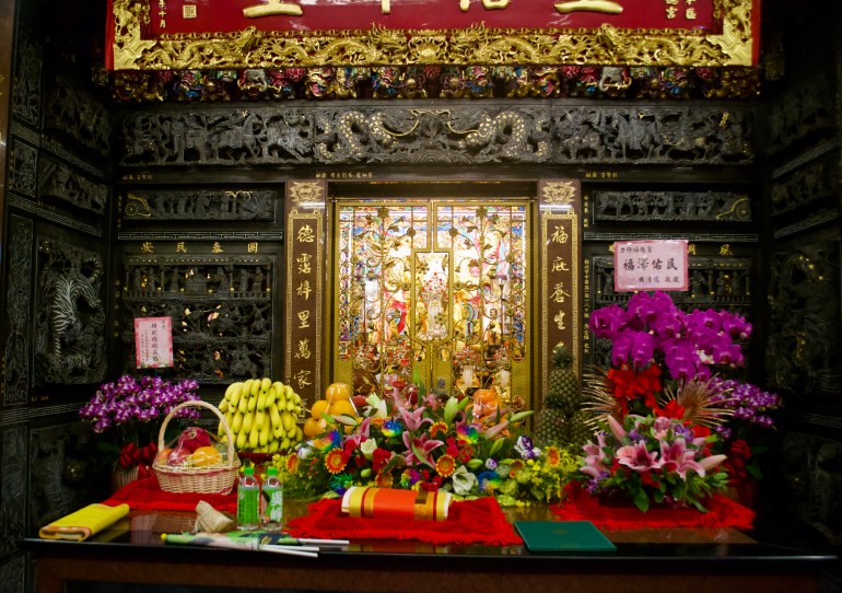 Offerings left on the altar at Lixing Fude temple. There are fresh fruit baskets, green flags and water bottles with Lai’s and Wu’s faces on them.