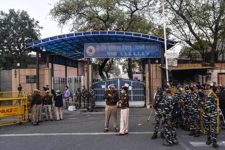 Police personnel seen as people gather to celebrate after four convicts in the December 2012 gang rape case were hanged at 5:30am in Tihar jail,