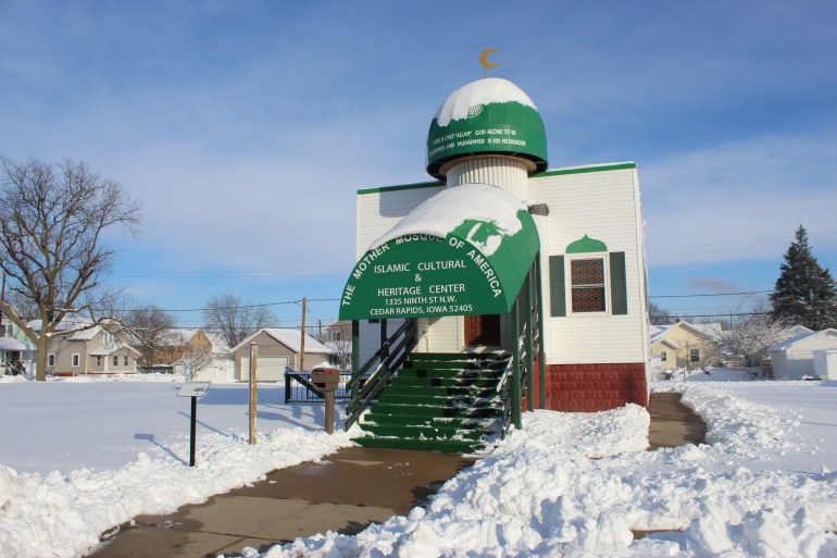 A view of the Mother Mosque of America in Iowa, a white building with a green dome and awnings.