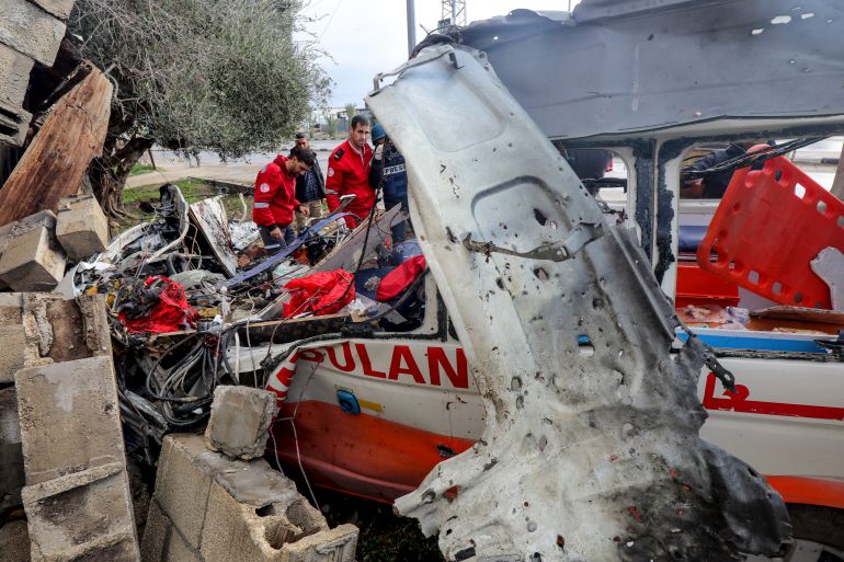 Palestinian Red Crescent personnel check a destroyed ambulance in Deir el-Balah in the central Gaza Strip, on January 11
