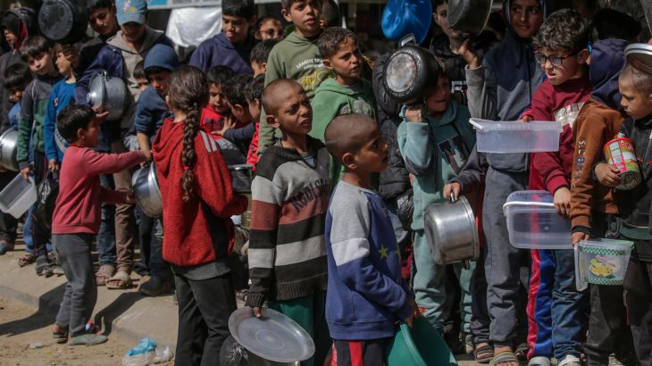 Internally displaced Palestinian children queue up