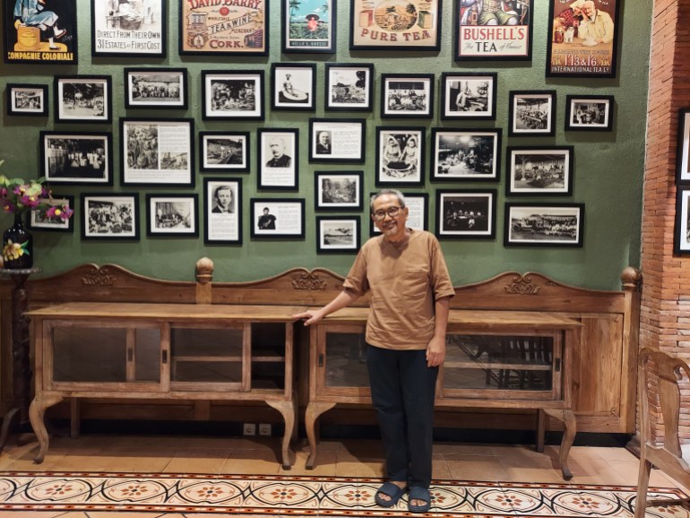 Family friend Slamet Raharjo, He is standing in front of a wall of photos