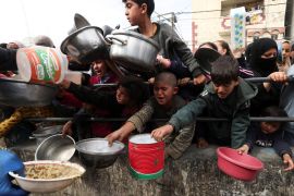 Palestinian children wait to receive food cooked by a charity kitchen amid shortages of food supplies, in the southern Gaza Strip, February 13, 2024 [Ibraheem Abu Mustafa/Reuters]