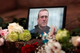 Flowers and a candle are placed next to a portrait of Russian opposition leader Alexei Navalny