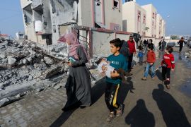Palestinians in Rafah walk past the rubble of a house destroyed by an Israeli strike, amid the ongoing war on Gaza [File: Saleh Salem/Reuters]