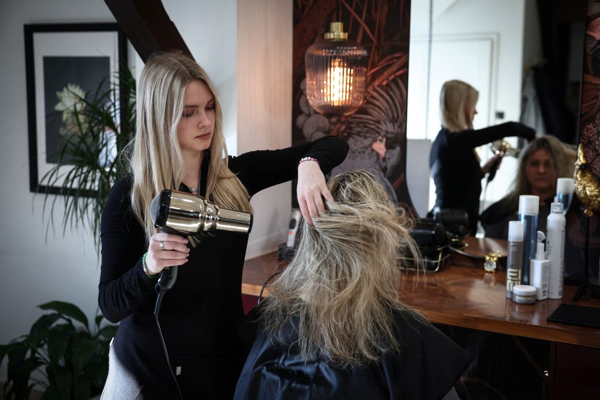 Dariia Vynohradova, 17, from Kharkiv, styles a customer's hair during her hairdressing apprenticeship at a salon in Gdansk, Poland, February 16