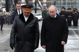 Russian President Vladimir Putin, right, and Defence Minister Sergey Shoigu speak after a wreath-laying ceremony marking Defender of the Fatherland Day at the Tomb of the Unknown Soldier by the Kremlin Wall in Moscow [File: Alexander Kazakov/Pool via Reuters]