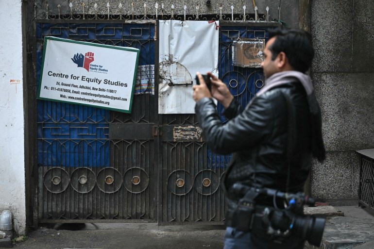 A media personnel takes photos of the office of 'Centre for Equity Studies' an advocacy outfit founded by activist Harsh Mander