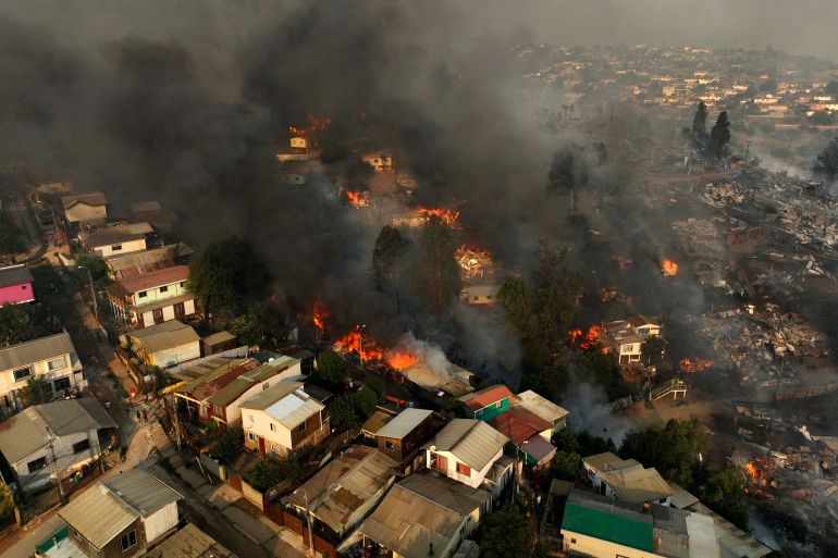 houses can be seen on fire from an aerial view