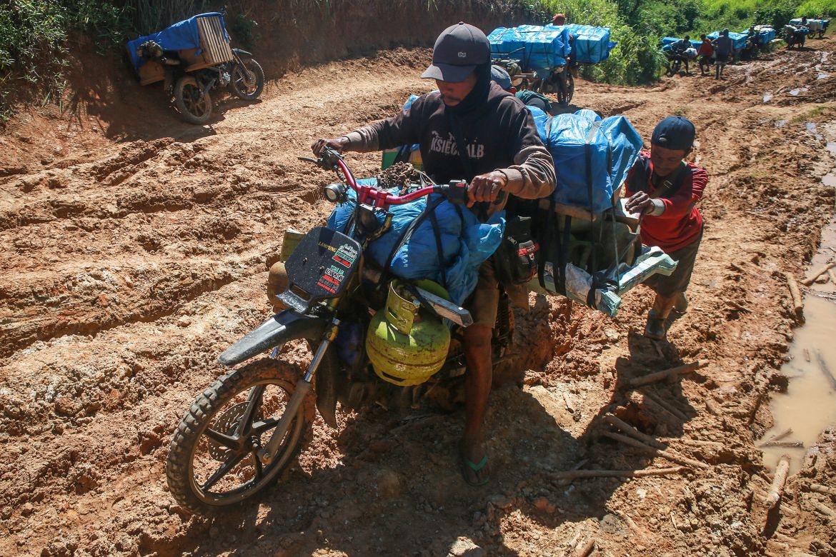 A member of logistics unit of the General Elections Commission (KPU) rides a motorbikes to deliver election materials by motorbike to remote polling stations by motorbikes as they use eighteen motorbikes and eight ox carts in Lampung, Indonesia, on February 11