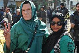 Woman wears imran Khan face mask, poses with another protestor