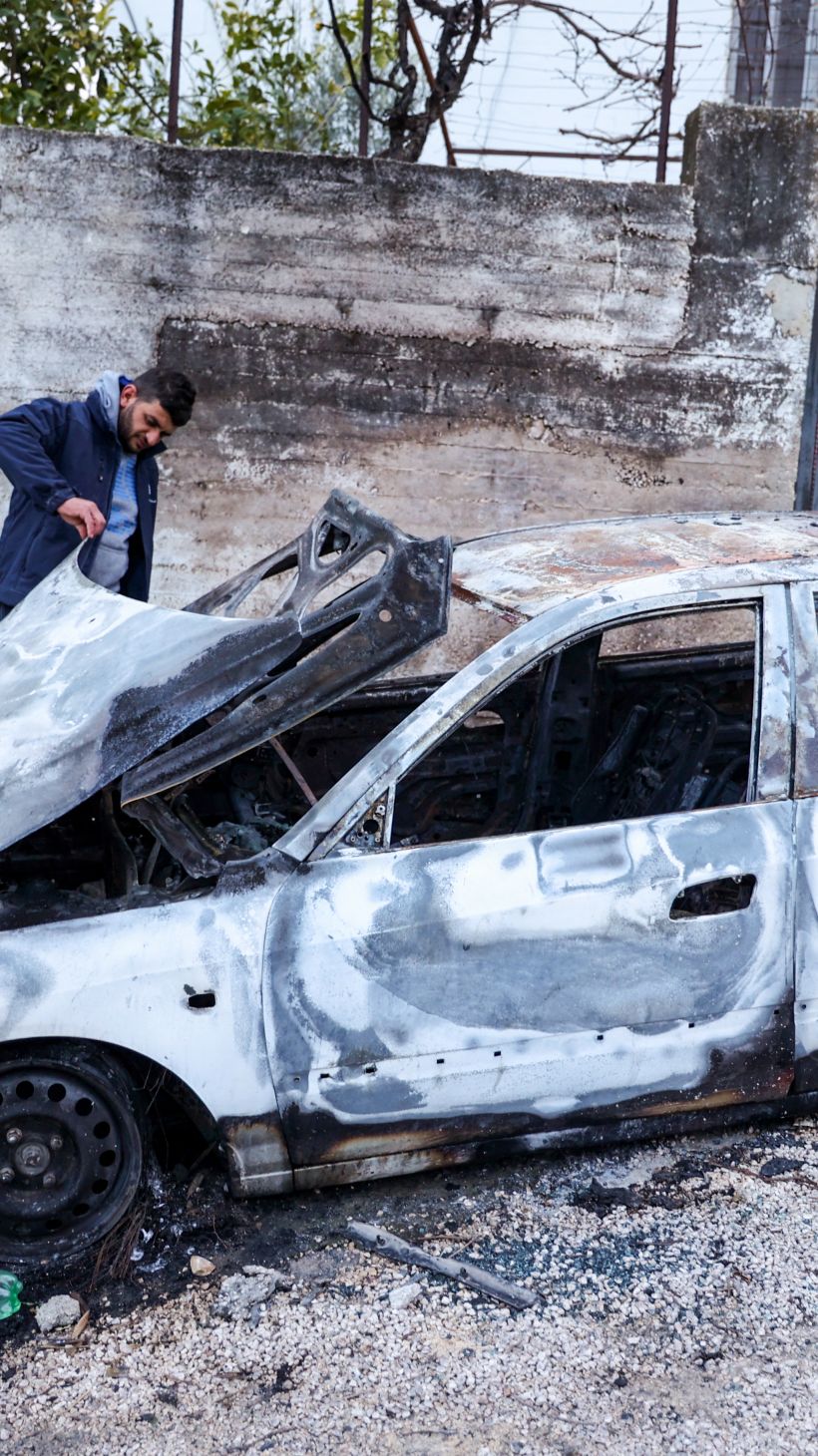 A Palestinian man inspects a car damaged