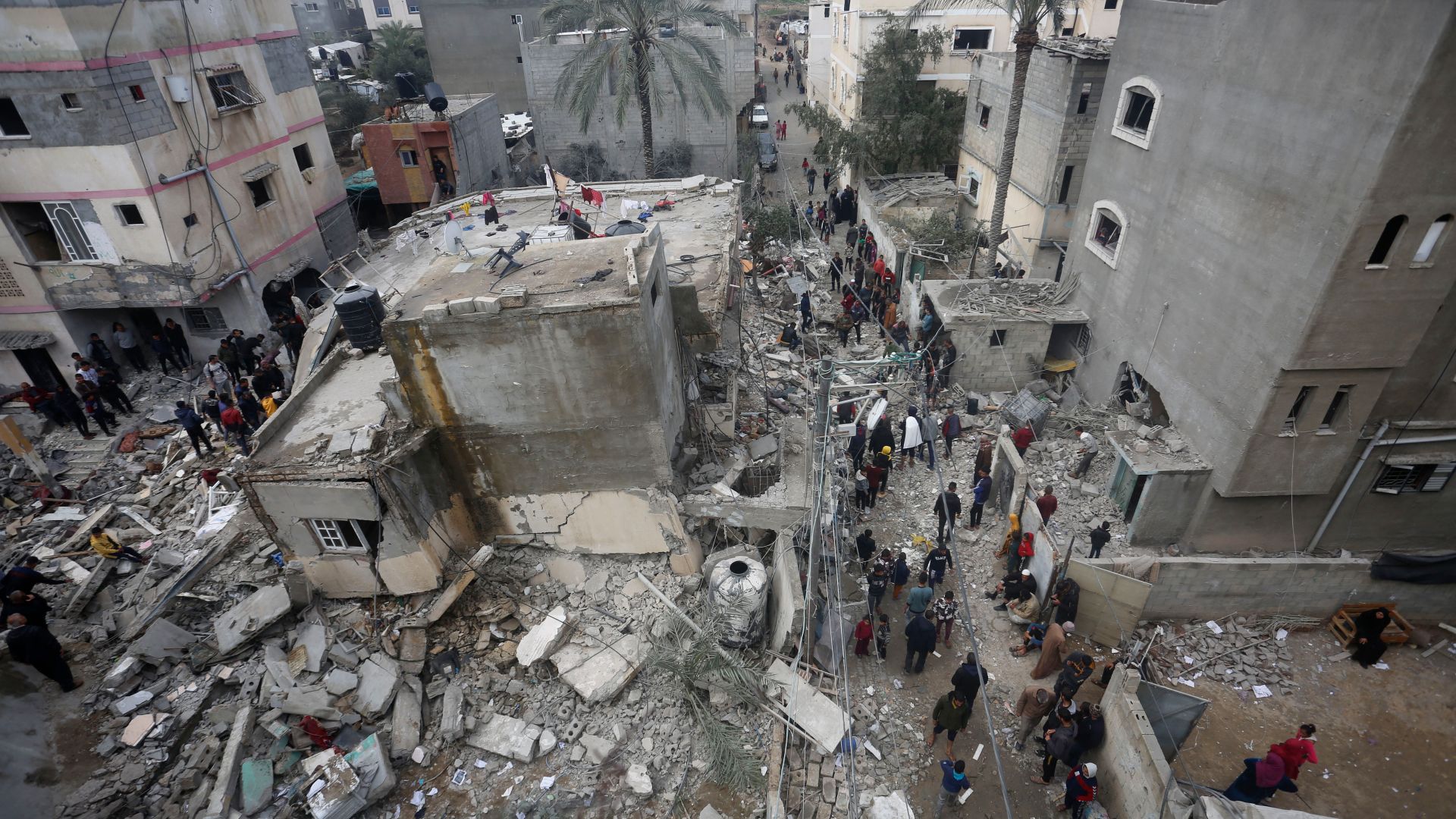 People search for victims in the rubble in Deir al-Balah in the central Gaza Strip after it was hit in an Israeli air strike on February 18, 2024