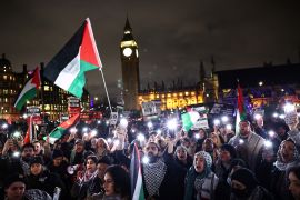 Pro-Palestinian demonstrators wave Palestinian flags and hold placards as they protest in Parliament Square in London on February 21, 2024 [Henry Nicholls/AFP]