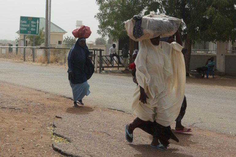 Women walk by the closed Niger-Nigeria border in Jibia
