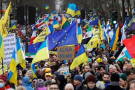 Participants wave European and Ukrainian flags during a rally for Ukraine on the second anniversary of Russia's invasion, in Paris on February