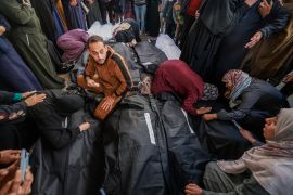 Palestinians mourn by the bodies of relatives who were killed in overnight Israeli air attacks on the Rafah refugee camp in the southern Gaza Strip on Tuesday [Mohammed Abed/AFP]