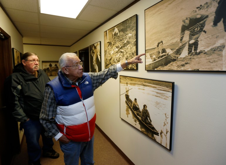 Indigenous elder Billy Frank Jr points to archival photos on the wall of the so-called "Fish Wars."