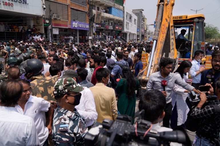 Residents of Shaheen Bagh surround officials during a demolition drive in New Delhi, Monday, May 9, 2022. Authorities in New Delhi stopped a demolition drive in a Muslim-dominated neighborhood after hundreds of residents and a number of opposition party workers gathered in protest Monday. No buildings were razed down before the bulldozers retreated.