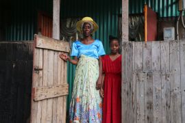 Zenabou S, a Comoros woman married to a French man in Mayotte and her French daughter, stand at their door step as they prepare to move, in the Talus 2 district of Koungou, in the French Indian Ocean territory of Mayotte Saturday,