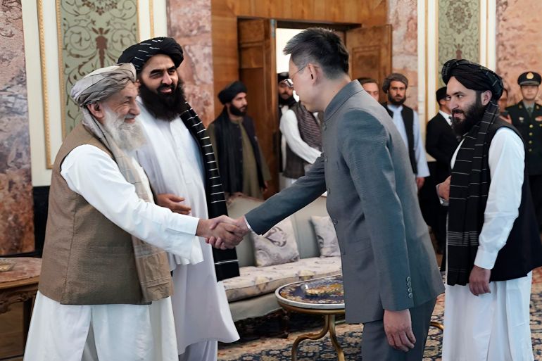 In this handout photo released by Taliban Prime Minister Media Office, China's new ambassador to Afghanistan Zhao Sheng shakes hand with Taliban Prime Minister Mohammad Hasan Akhund, left, during the recognition ceremony at the Presidential Palace, in Kabul, Afghanistan, Wednesday, Sept. 13, 2023. The Taliban on Wednesday greeted China's new ambassador to Afghanistan with pomp and ceremony, calling the envoy's nomination a significant step with a significant message. (Taliban Prime Minister Media Office via AP)