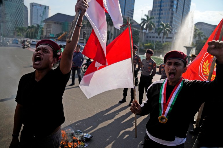 Students on the streets of Jakarta amid concerns about Indonesia's democracy. They are carrying Indonesian flags and raising their fists