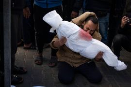 A man holds the body of his daughter who was killed in an Israeli attack on the Gaza Strip, at a hospital morgue in Rafah, on February 21, 2024 [Fatima Shbair/AP Photo]