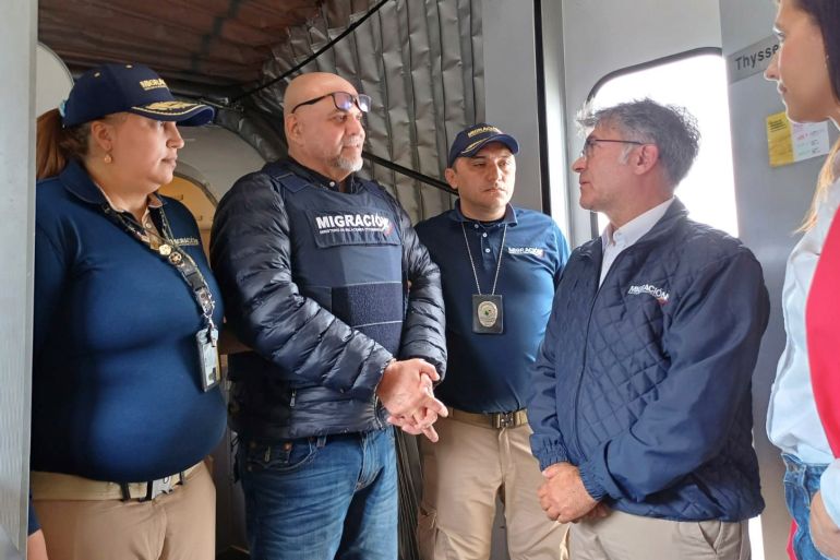 In this photo released by the Colombian Immigration agency, migration officials meet former Colombian paramilitary leader, Salvatore Mancuso, at the gate of the plane at El Dorado International Airport in Bogota, Colombia, Tuesday, Feb. 27, 2024, upon arrival from the U.S. which deported him after he served time for drug trafficking. (Colombian Immigration Agency via AP)