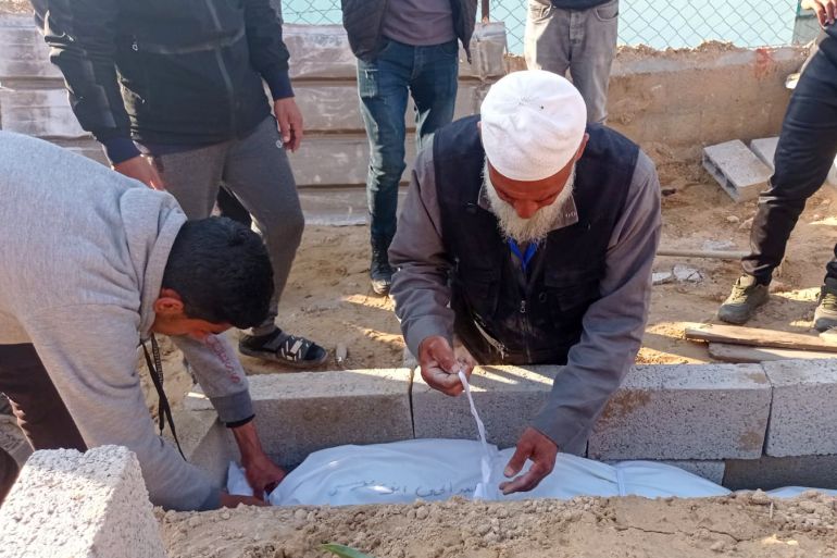 Abu-Jawad putting a corpse of a 14-year-old child shot dead by an Israeli sniper in Khan Younis