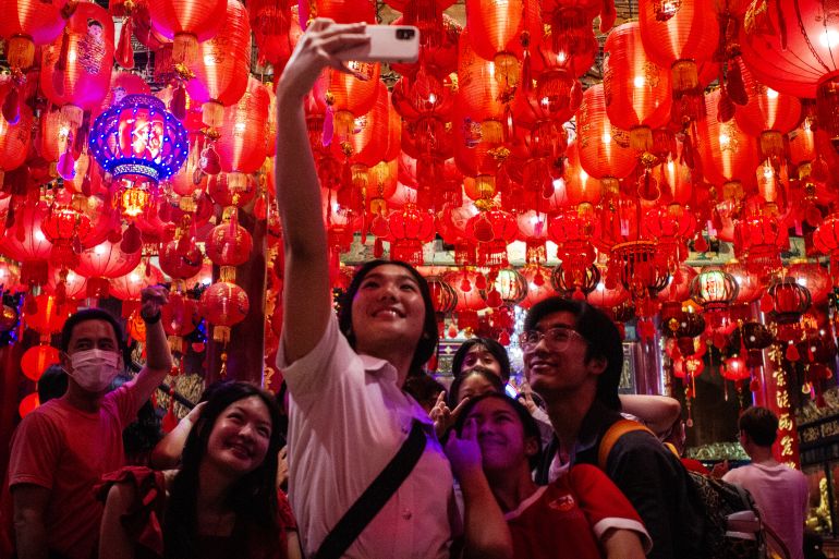 Tourists taking pictures beneath lanterns in Bangkok's Chinatown