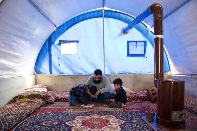Ibrahim with his sons in a blue-tinted tent