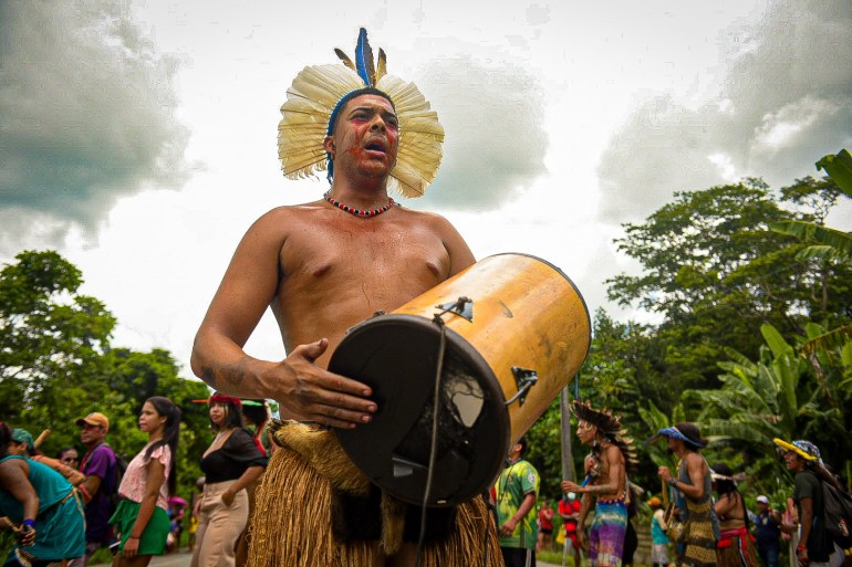 A Pataxó Hã-Hã-Hãe man beats a hand-held drum at an outdoor protest