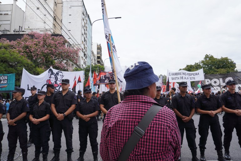 A protester in Buenos Aires stands in front of a row of police officer.