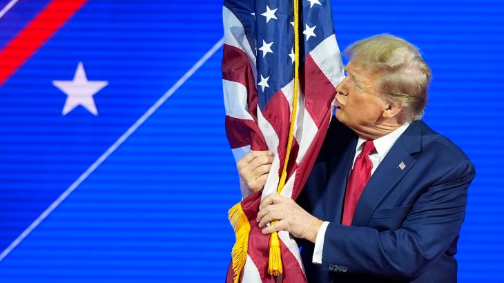 Trump kisses the flag of the United States.