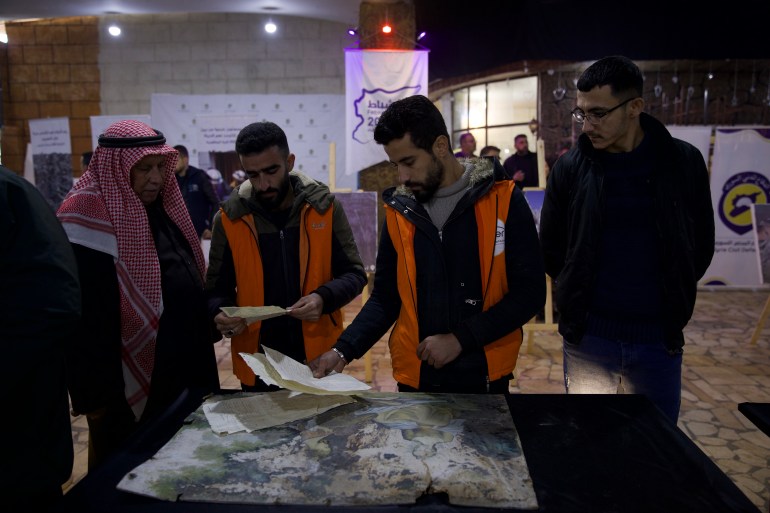 Visitors view models of the earthquake disaster during an exhibition commemorating its first anniversary in the city of Jenderes in the northern countryside of Aleppo