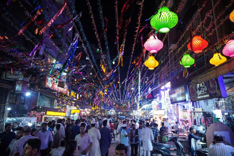 A night view of Shaheen Bagh food street lit up with decorative string lights. [Meer Faisal/Al Jazeera]