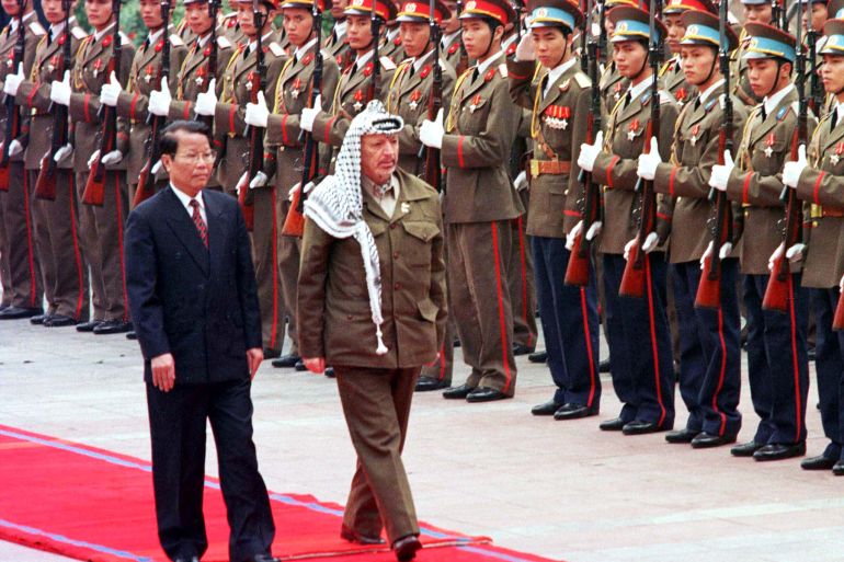 Palestinian President Yasser Arafat walks with Vietnamese President Tran Duc Luong as he inspects an honour guard at his formal welcoming ceremony in Hanoi April 9. Arafat has been on a whirlwind international tour aimed at gauging support for a unilateral Palestinian declaration of independence once an interim self-rule agreement with Israel expires in May. AJS/DL